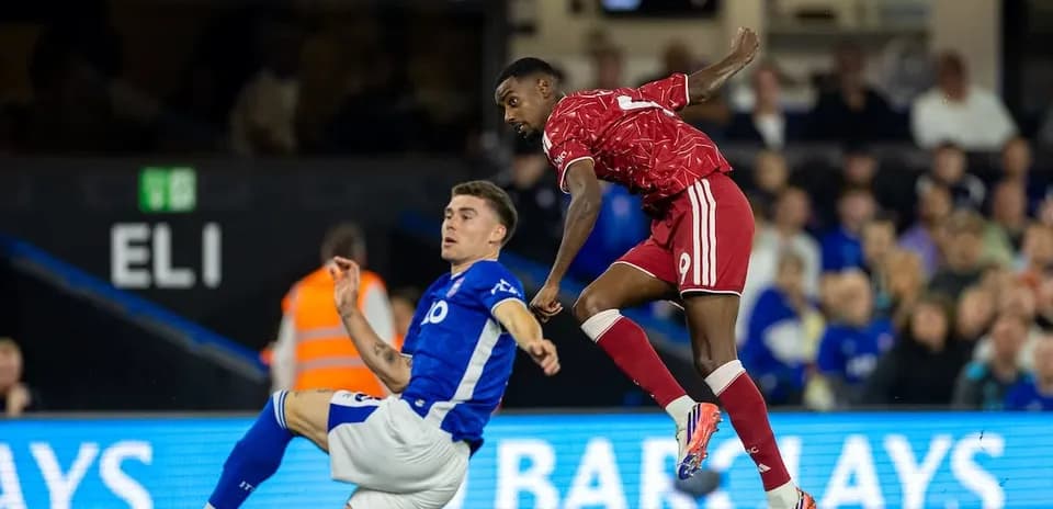 Ipswich player tackling Liverpool forward during match