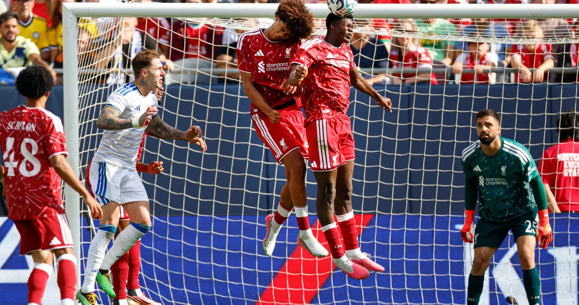 Two players heading the ball in front of goal