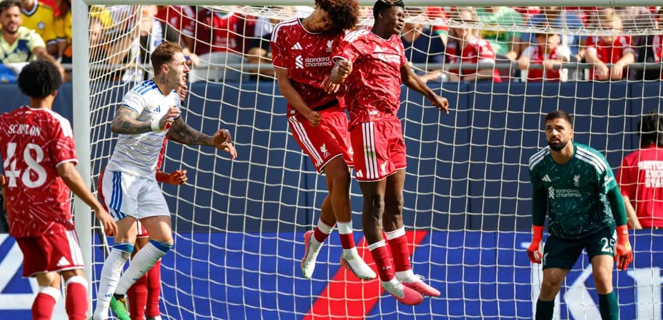 Two players heading the ball in front of goal