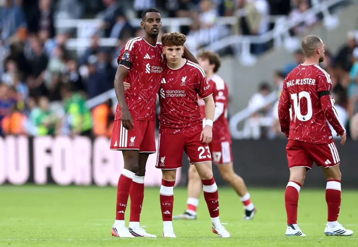 Two Liverpool players in red kits on field