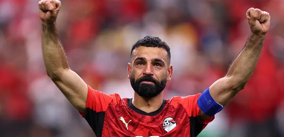 Player celebrating with raised arms in national jersey