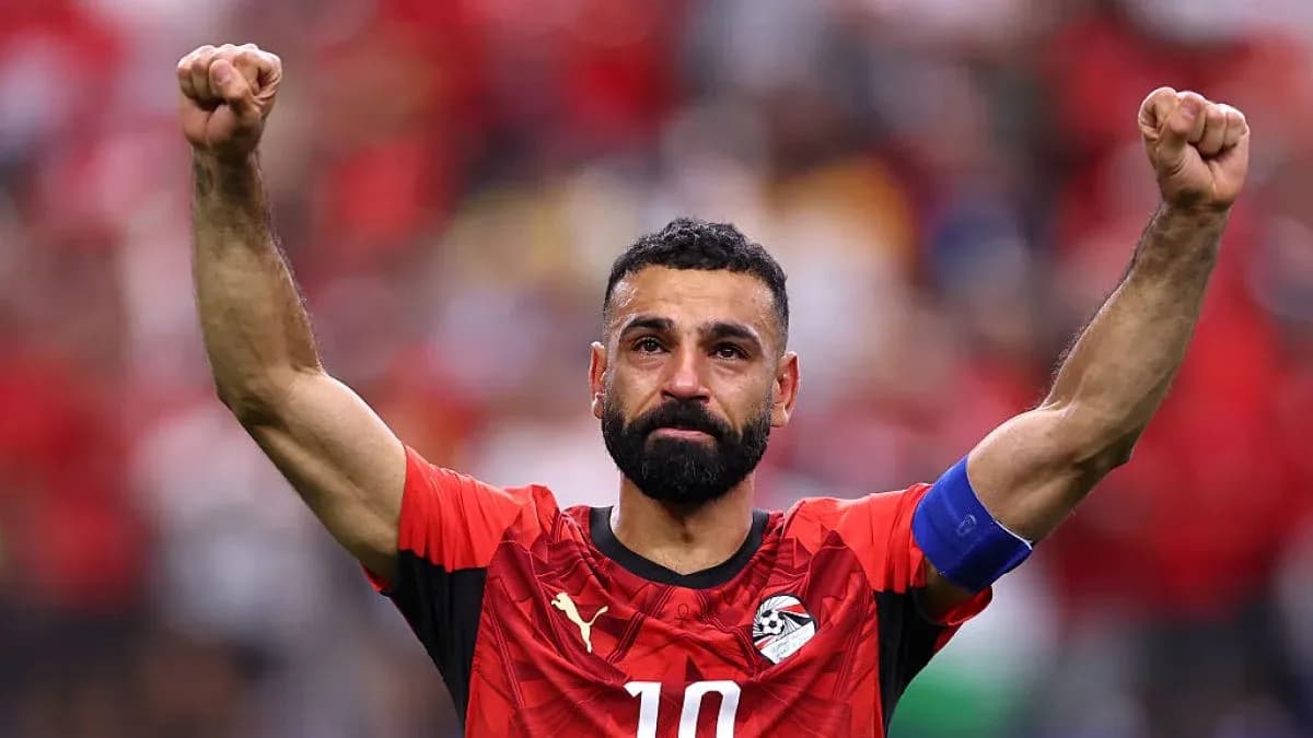 Player celebrating with raised arms in national jersey