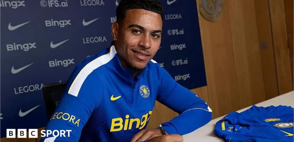 Player signing contract at press conference table