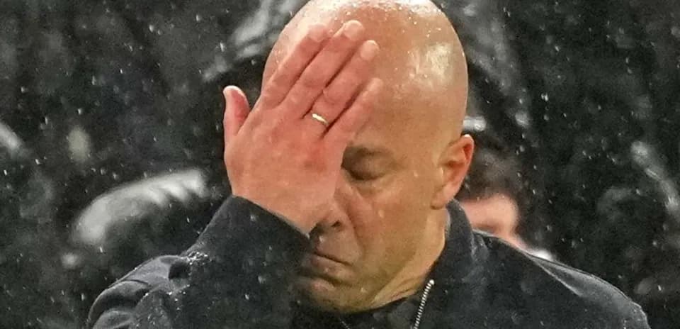 Coach with hand on forehead during match