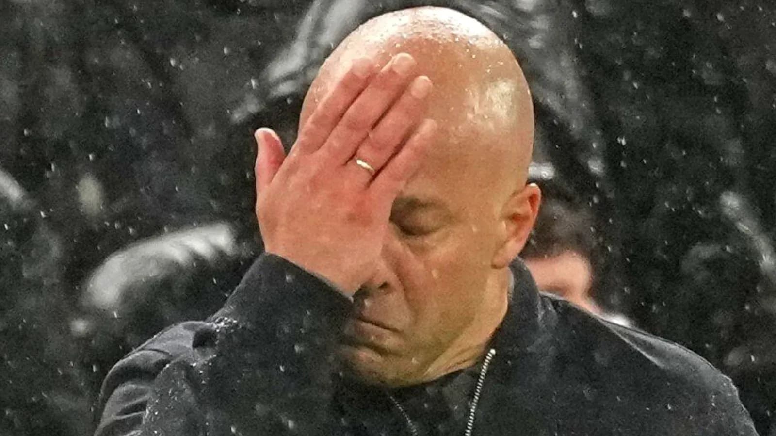 Coach with hand on forehead during match