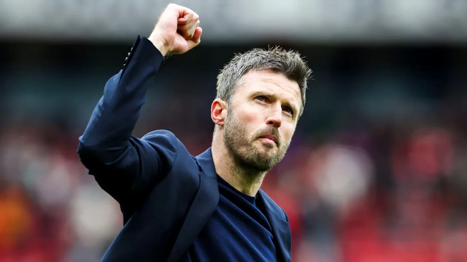 Coach celebrating with raised fist on pitch