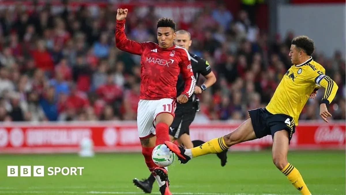 Player in red jersey avoiding a tackle during match
