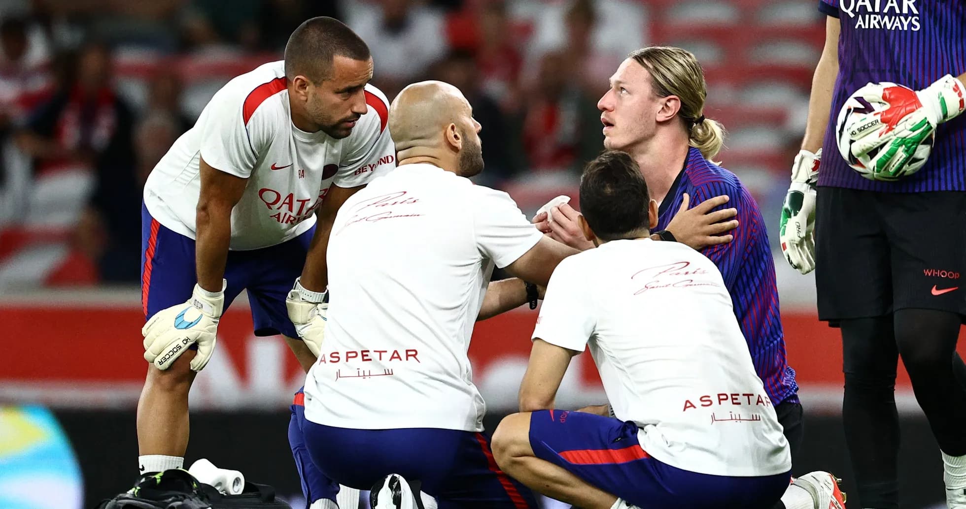 Players and medical staff attending to injured teammate