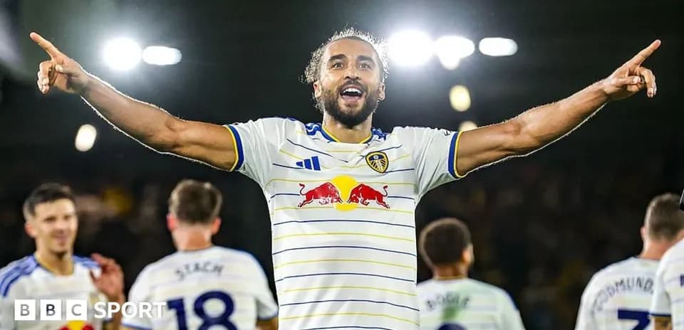 Player celebrating a goal with teammates in stadium