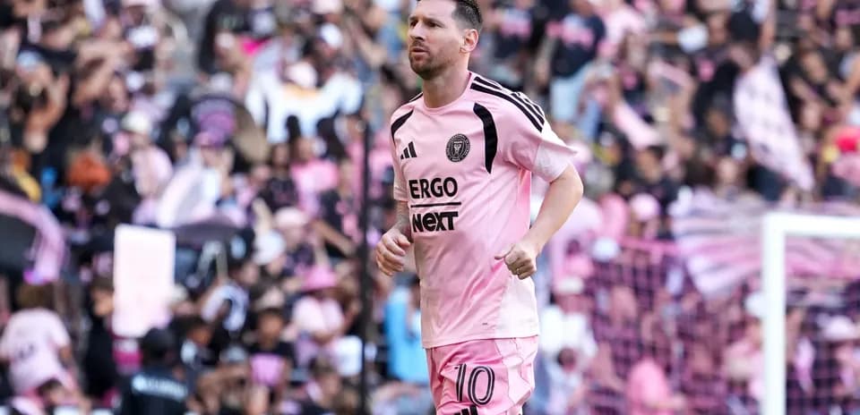 Lionel Messi running on field in pink uniform