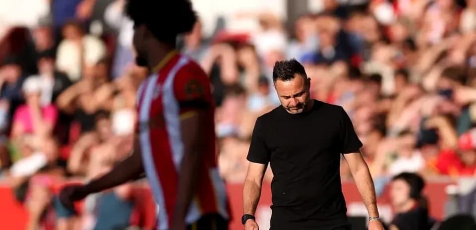 Manager walking off the pitch with player behind