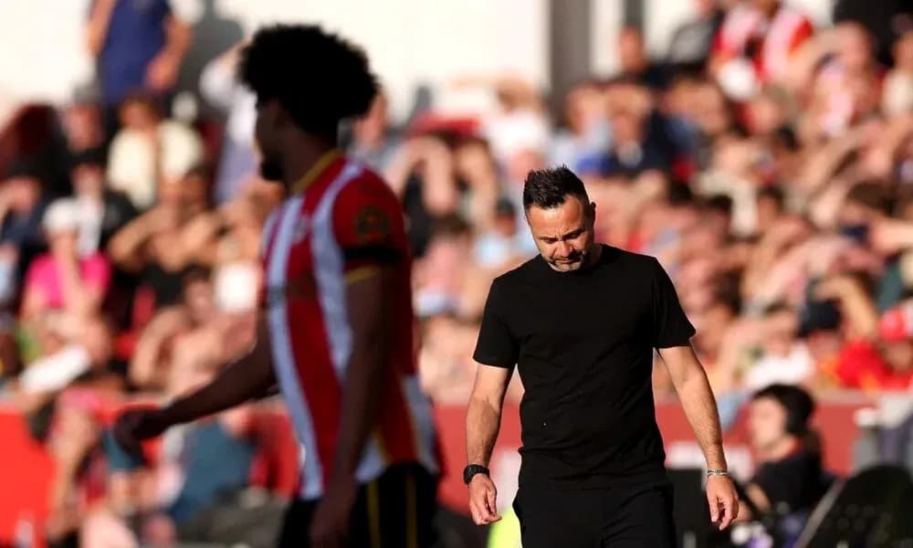 Manager walking off the pitch with player behind