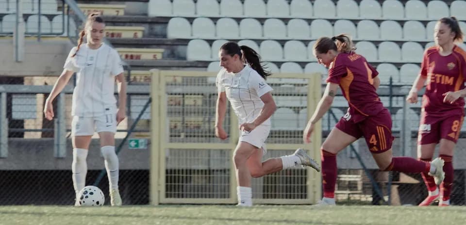 Como W player dribbling against Parma W defenders