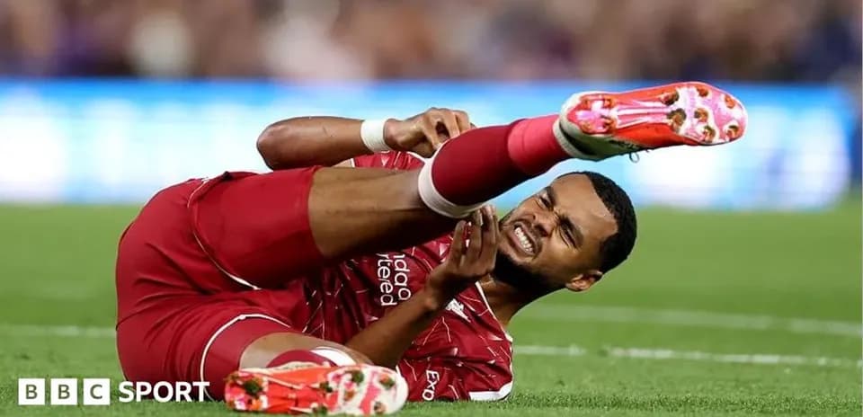 Player in red kit lying injured on the pitch