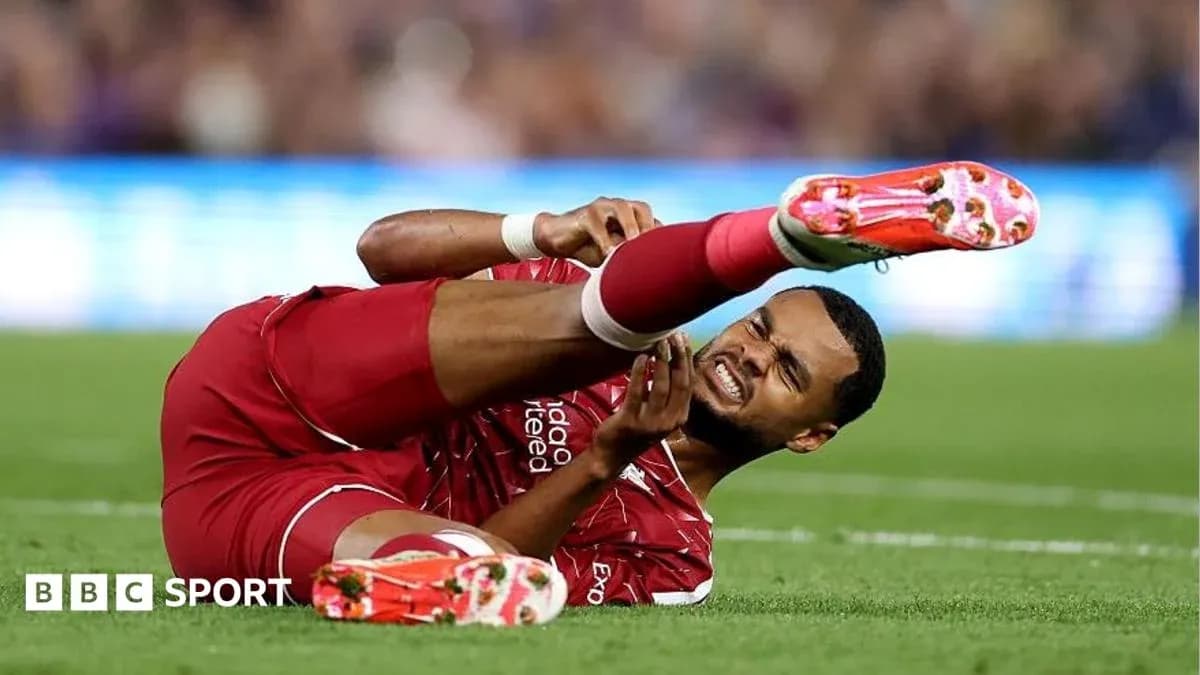 Player in red kit lying injured on the pitch