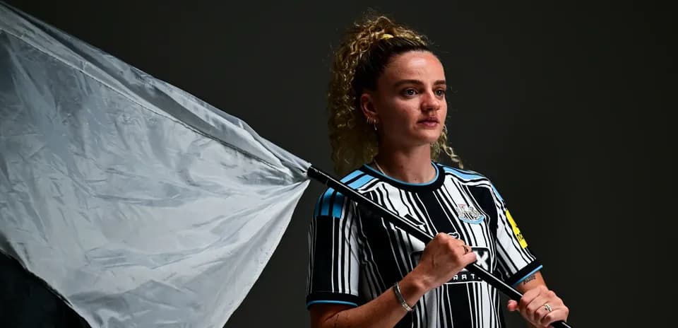 Player holding a flag wearing Newcastle jersey