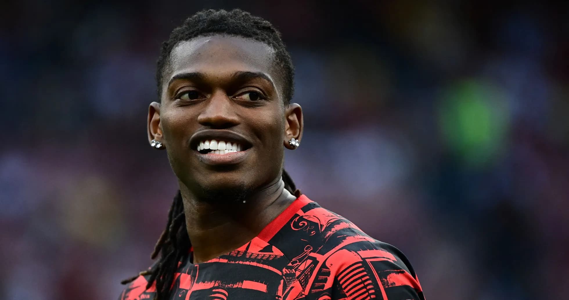 Player smiling while wearing red patterned jersey