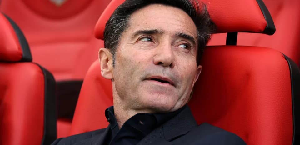 Coach seated on bench during match