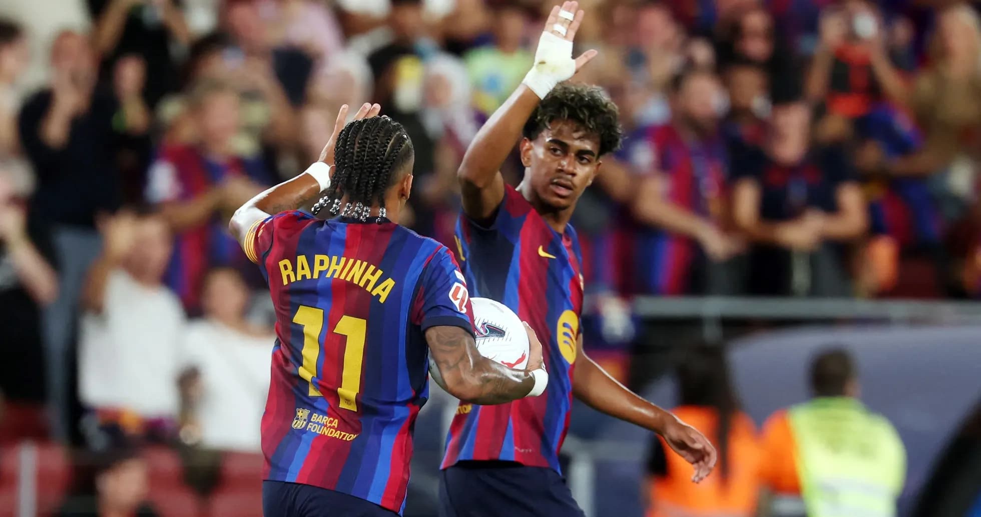 Two FC Barcelona players celebrating a goal