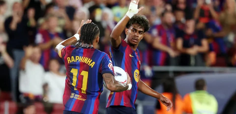 Two FC Barcelona players celebrating a goal