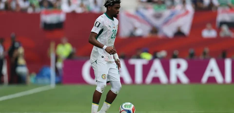 Player in Senegal jersey controlling soccer ball on field