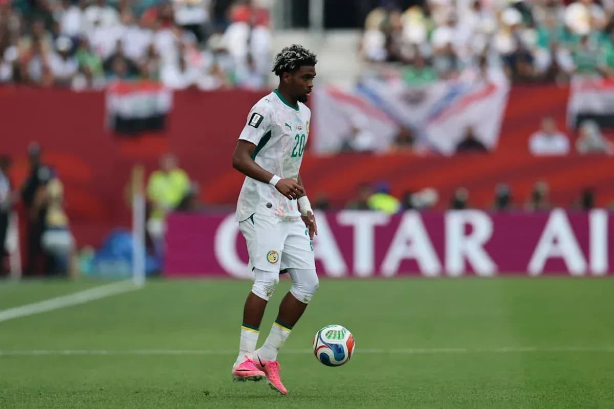 Player in Senegal jersey controlling soccer ball on field