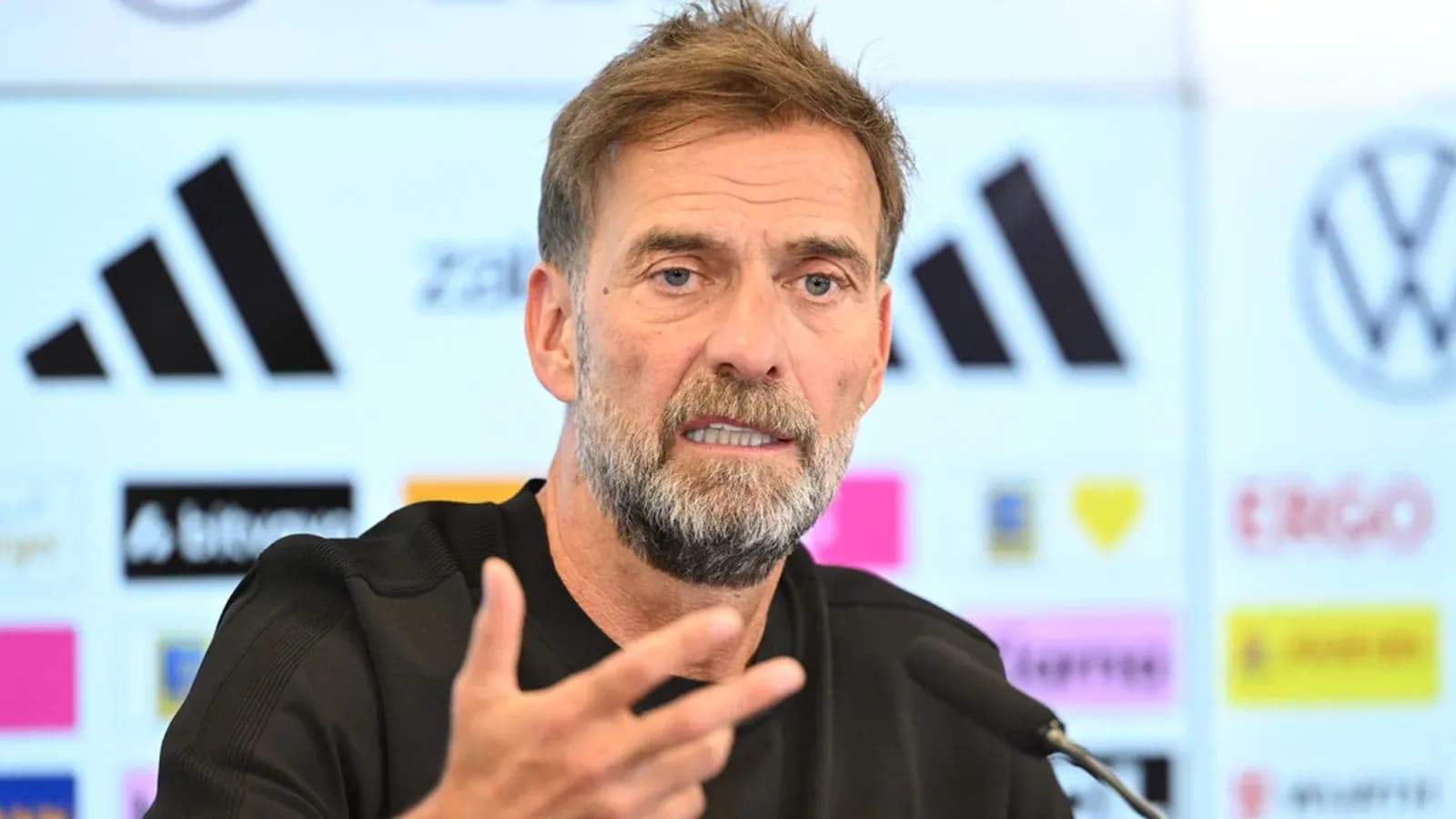 Manager speaking at press conference with backdrop