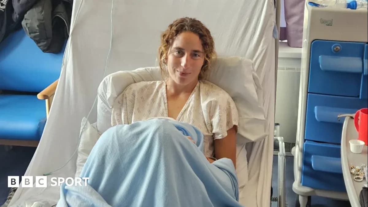 Athlete sitting in hospital bed wearing gown