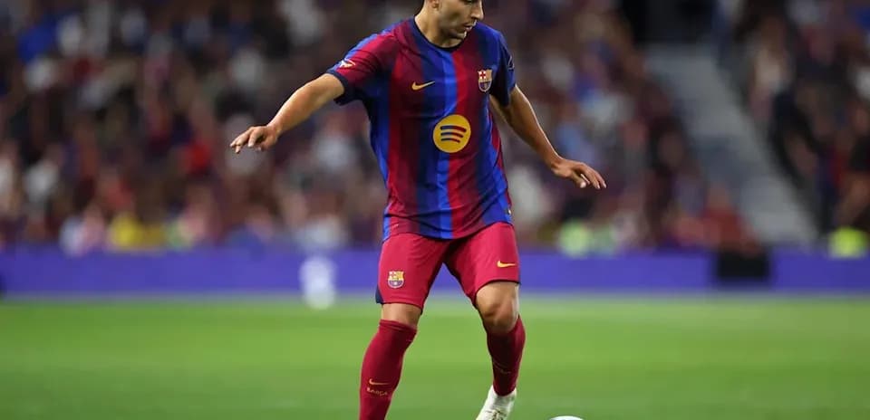 Player in Barcelona kit controlling the ball on field
