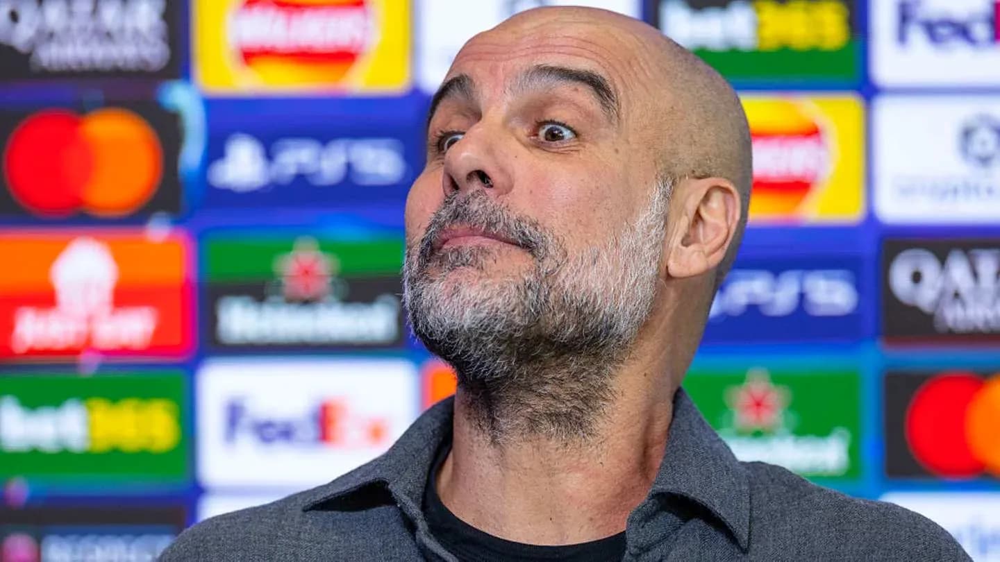 Manager at press conference with sponsor logos behind