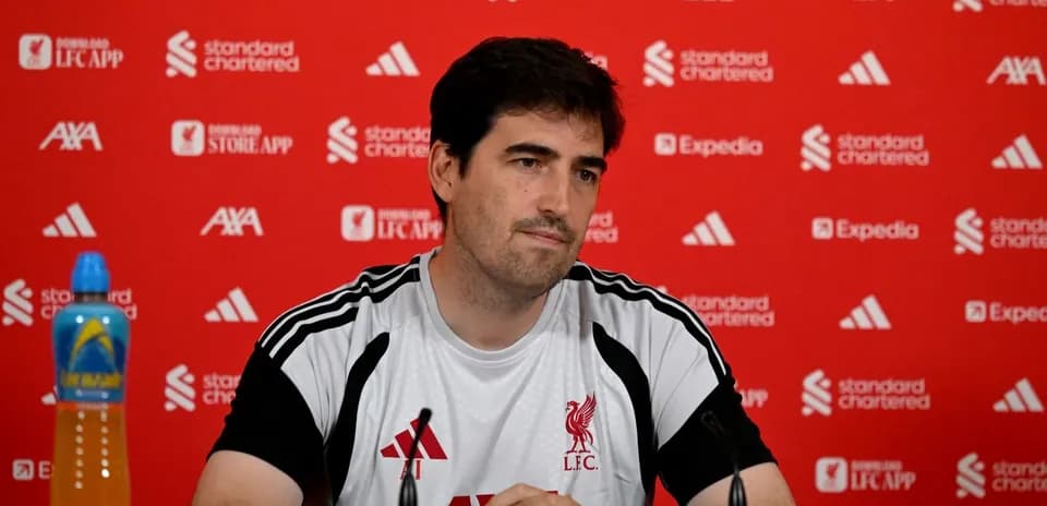 Manager at press conference with Liverpool branding backdrop