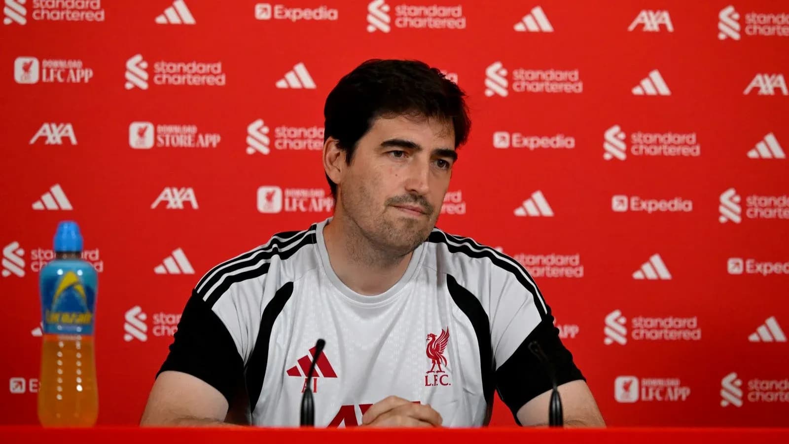 Manager at press conference with Liverpool branding backdrop