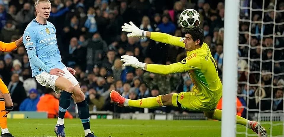 Erling Haaland shooting against Real Madrid goalkeeper