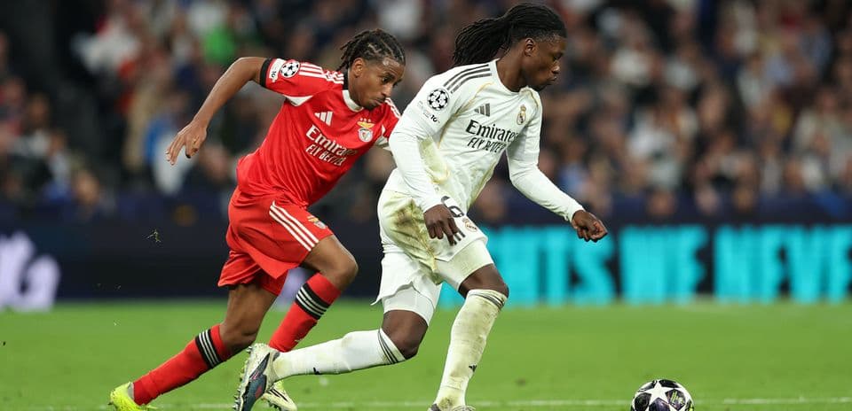 Real Madrid player dribbling past Benfica defender