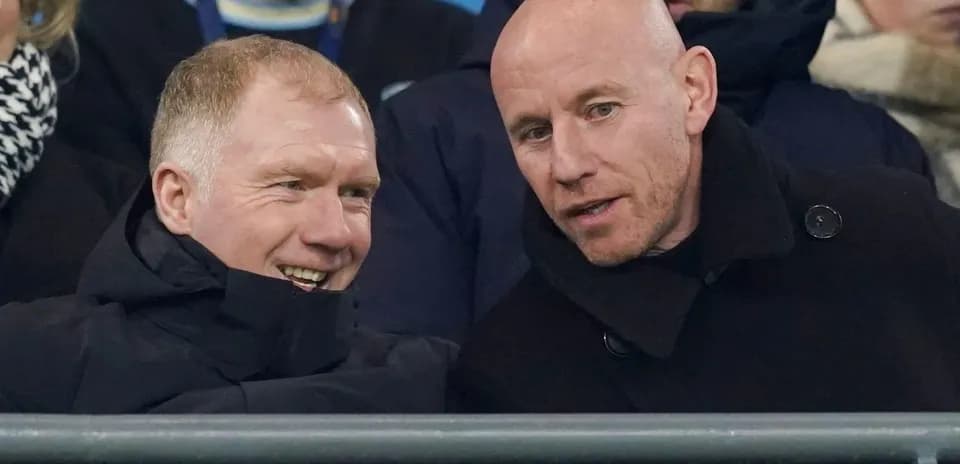 Two men chatting in the stands at a match