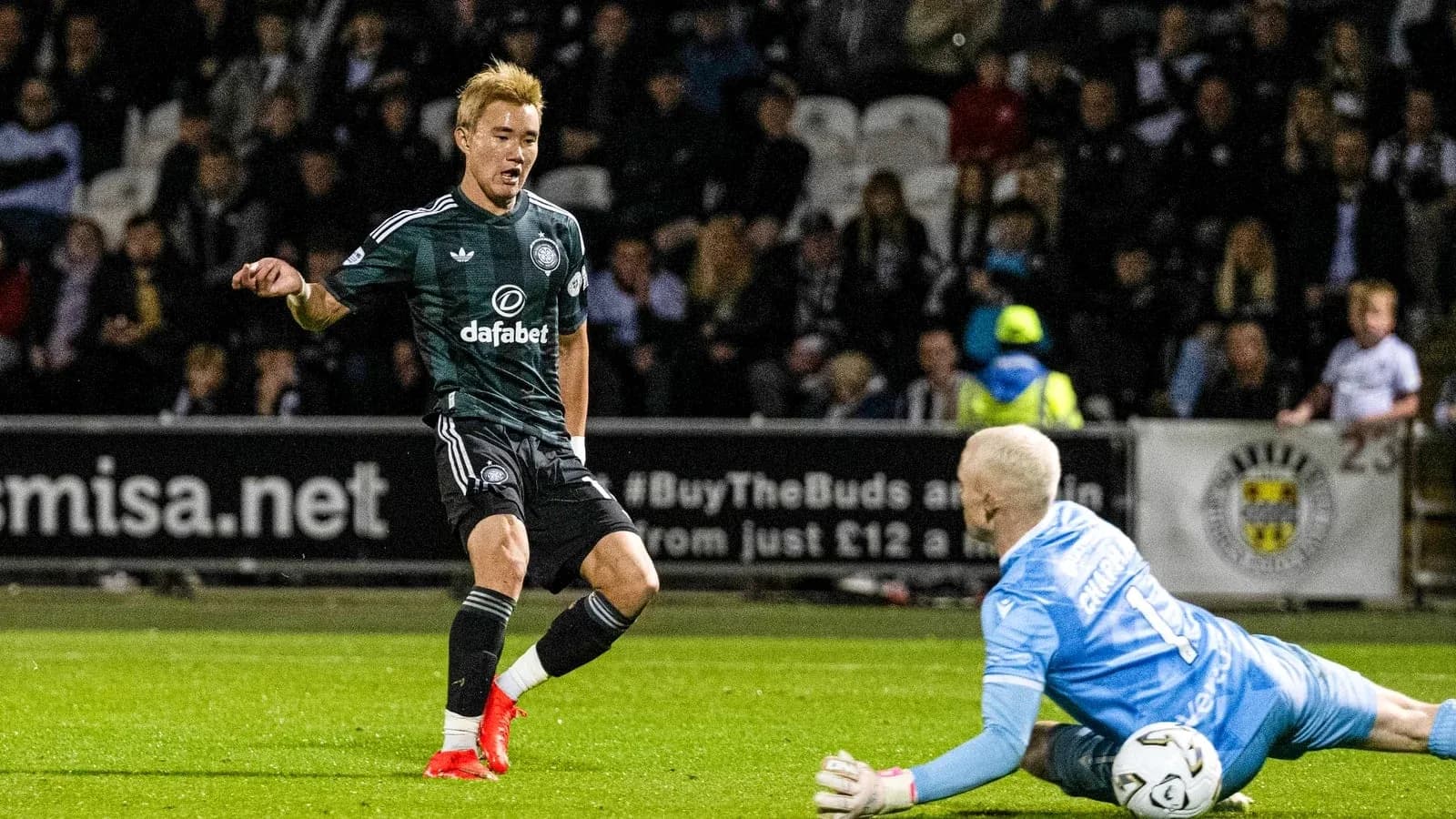 Player dribbling past goalkeeper during match