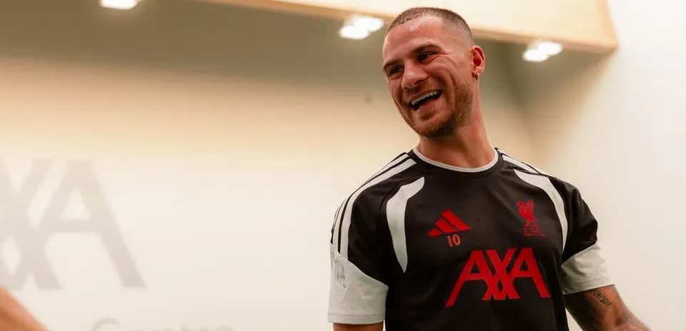 Player smiling in Liverpool training kit indoors