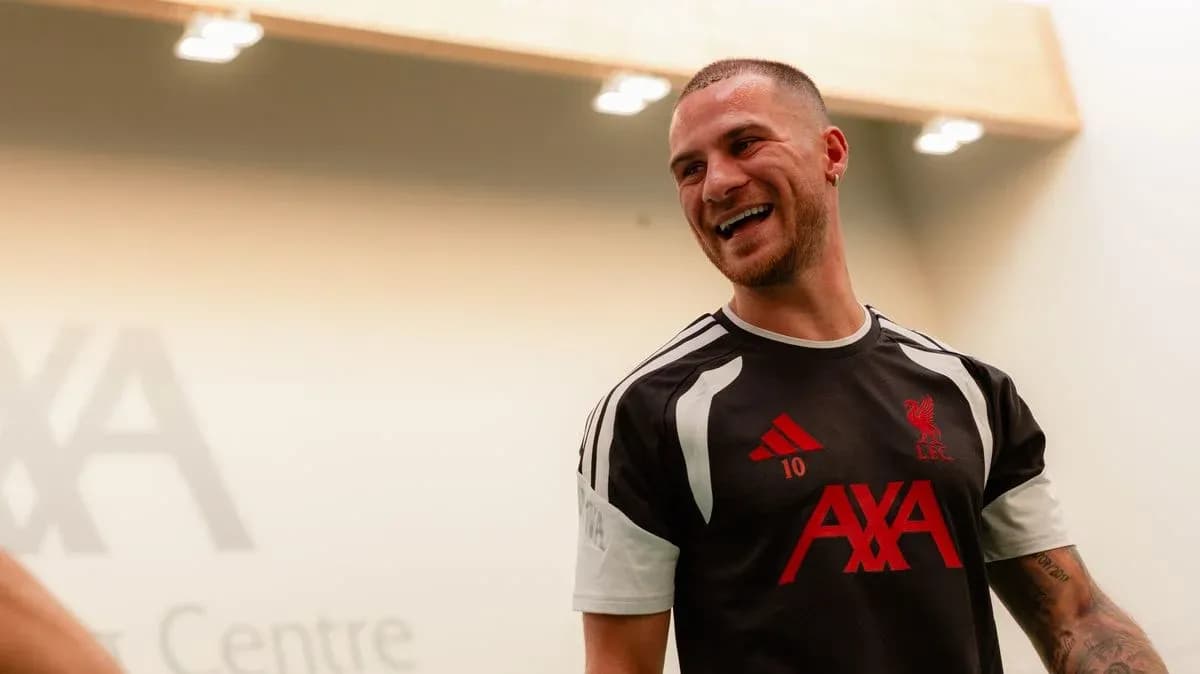 Player smiling in Liverpool training kit indoors