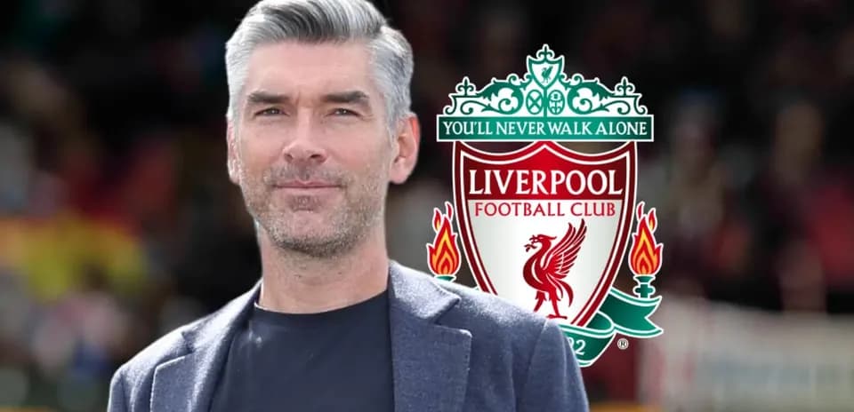 Person standing in front of Liverpool FC logo