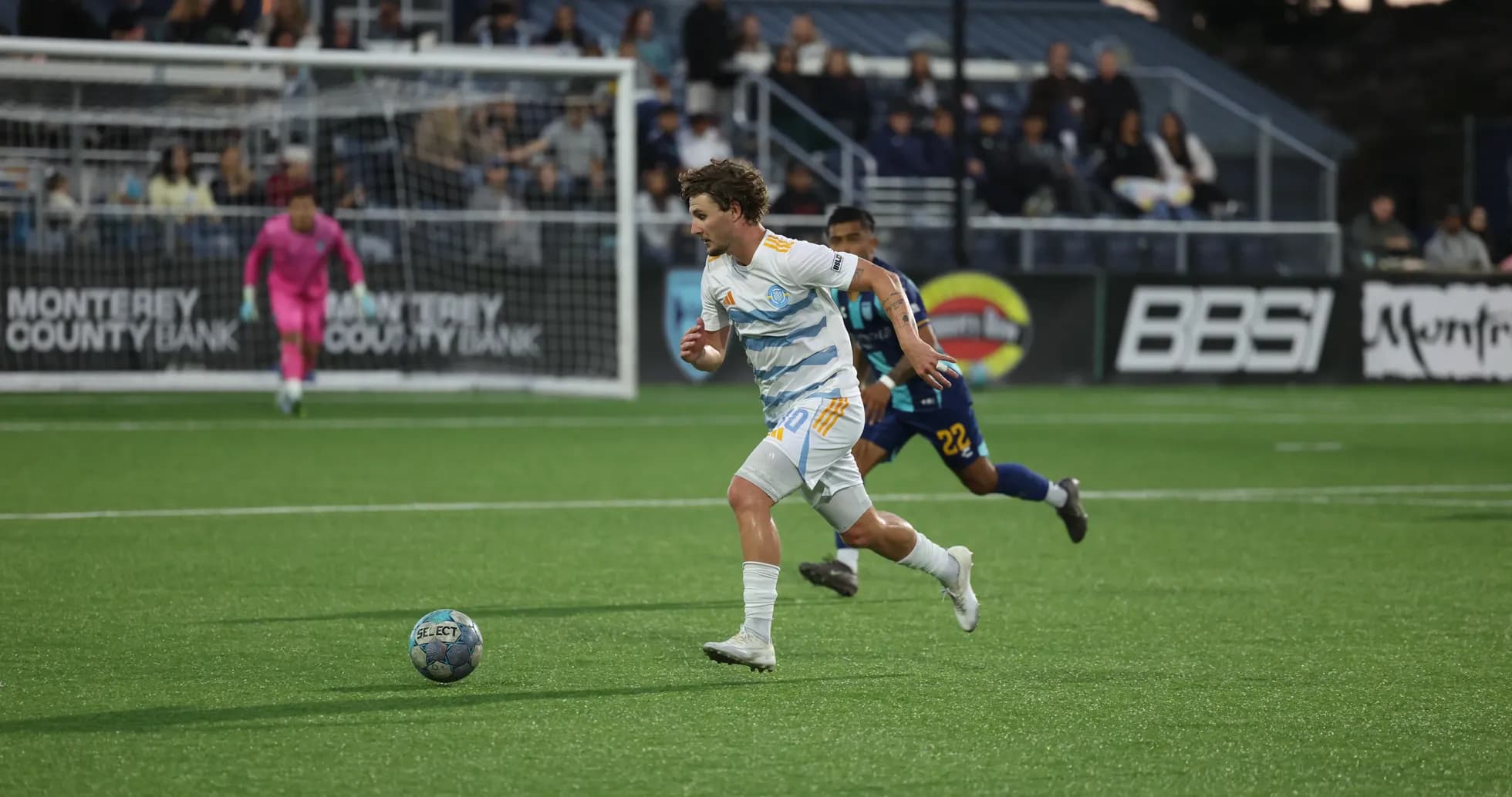 Player sprinting with ball during Monterey Bay match