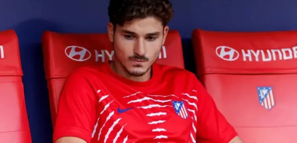 Player sitting on bench in Atlético Madrid kit