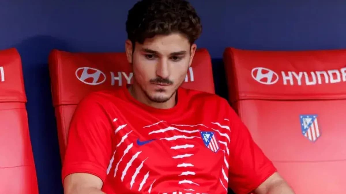 Player sitting on bench in Atlético Madrid kit