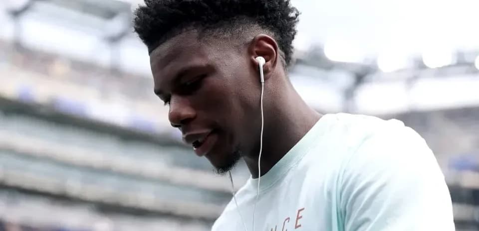 Player wearing earbuds, looking down at the field