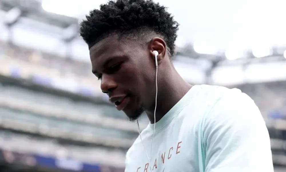 Player wearing earbuds, looking down at the field