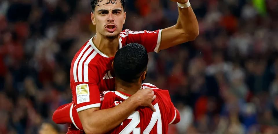 Player celebrating a goal with teammate in stadium