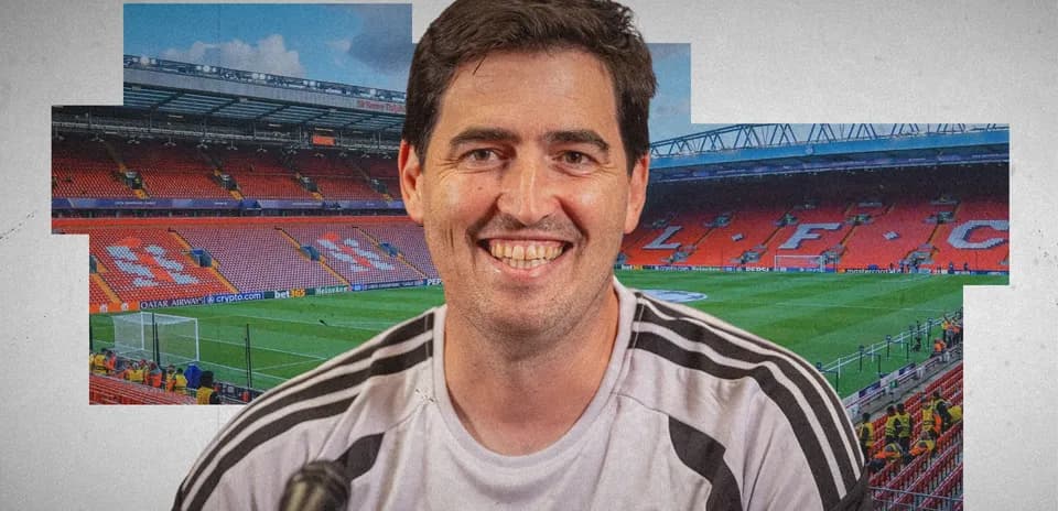 Coach smiling with Anfield stadium in background