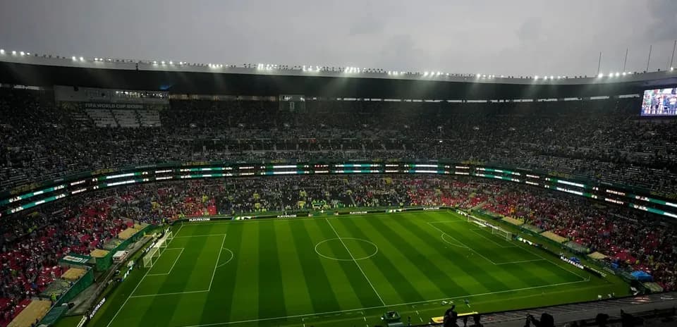 Empty stadium with green pitch before match
