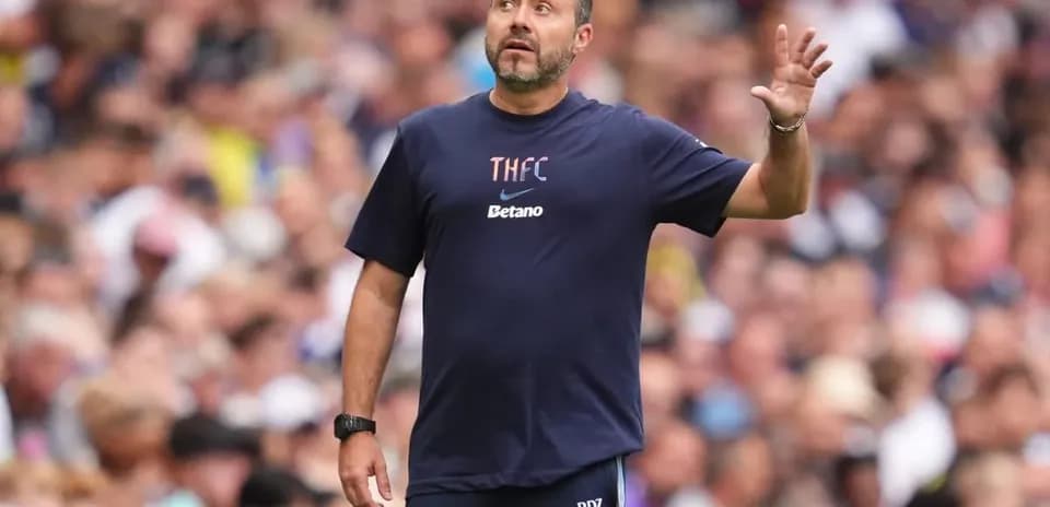 Coach gesturing during match in front of crowd