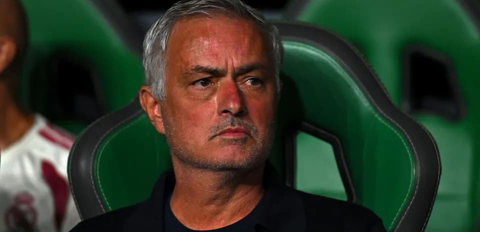 Manager sitting on bench during a match