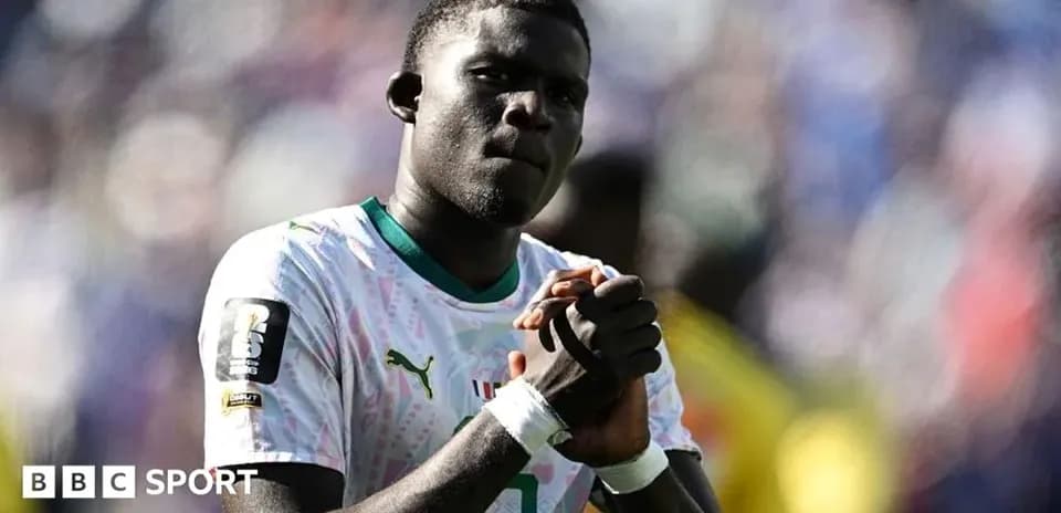 Player in white jersey clasping hands on field